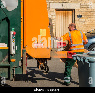 Un conseil ouvrier en tenant le carton déchets à la refuser camion sur une journée ensoleillée. Langtoft, près de Peterborough. Lincolnshire, Angleterre, Royaume-Uni. Banque D'Images