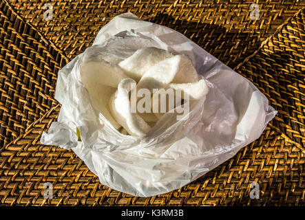 Ouvrir un paquet de chips de crevettes croustillantes sur un set de table en osier - partie d'un repas chinois à emporter. Angleterre, Royaume-Uni. Banque D'Images