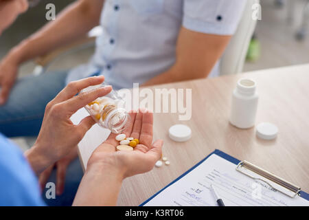 Gros plan du jeune femme médecin donnant des pilules et vitamines au patient in office Banque D'Images
