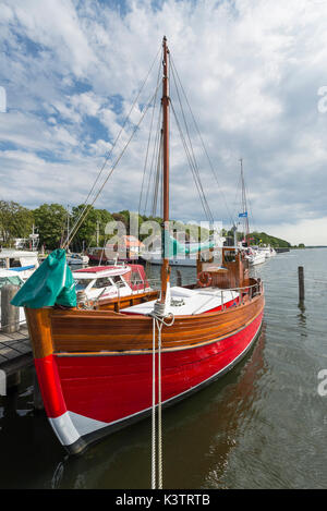 Fischerboot aus holz mit rotem rumpf im hafen von kloster auf der Insel hiddensee dans der morgensonne, mecklenburg-vorpommern, Deutschland Banque D'Images