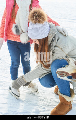 Femme avec enfant permet de patins à glace en hiver dans la neige Banque D'Images