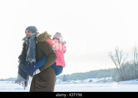 Père donne piggyback ride en fille en hiver et de s'amuser Banque D'Images