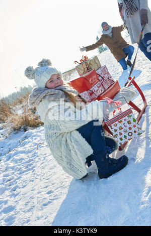 Don de la famille de nombreux cadeaux de noël à traineau en hiver Banque D'Images