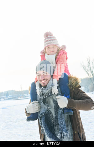 Père sourit et donne à l'amitié entre fille dans la neige en hiver Banque D'Images