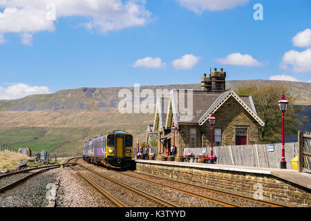 Passagers attendant train approchant Ribblehead sur station régler à Carlisle railway. Yorkshire Dales National Park North Yorkshire Angleterre UK Banque D'Images