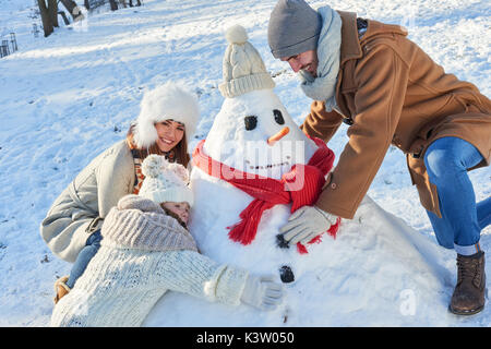 Appuie la famille snowman ensemble en hiver dans le parc Banque D'Images