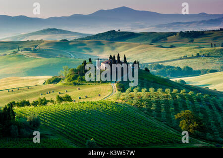 La toscane, italie. Une belle et solitaire ferme entourée de vertes collines de la Val d'Orcia Banque D'Images