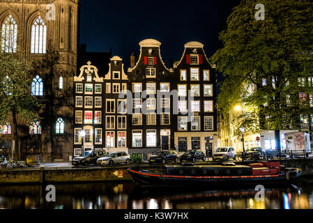 Amsterdam, Pays-Bas, Europe. Les bâtiments anciens traditionnels reflète la nuit dans le canal. Banque D'Images