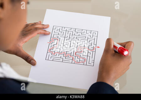 Close-up of a Businesswoman Résoudre Labyrinthe Casse-tête avec le marqueur rouge Banque D'Images