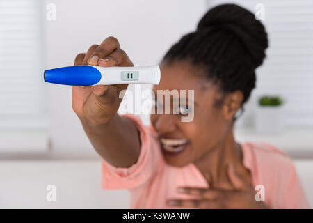 Close-up of Smiling Woman Holding Test de Grossesse Banque D'Images