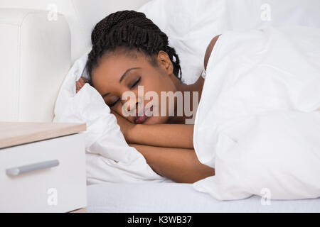 Portrait d'une jeune femme africaine de dormir sur le lit Banque D'Images