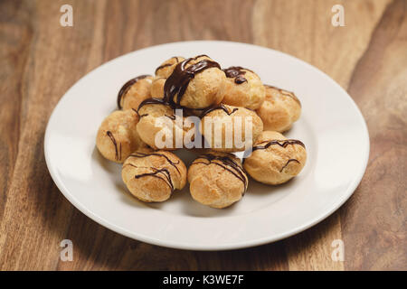 Profiteroles au chocolat noir fin sur la plaque Banque D'Images