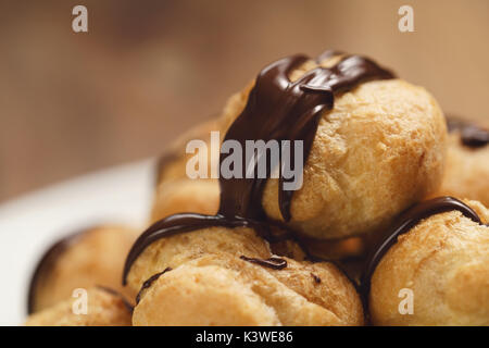 Profiteroles au gros plan sur la plaque de chocolat noir fin Banque D'Images