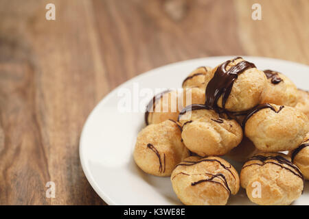 Profiteroles au chocolat noir fin sur la plaque Banque D'Images