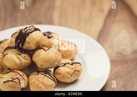 Profiteroles au chocolat noir fin sur la plaque Banque D'Images