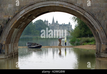 Père et fille chat sur l'équitation de Burghley House et à proximité du pont lion. Banque D'Images