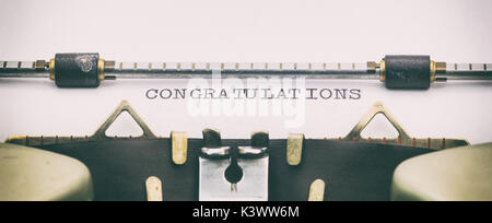 Close-up of félicitations mot en majuscules sur papier blanc en machine à écrire Banque D'Images