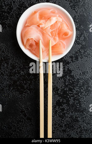 Tranches de gingembre mariné sushi dans un bol. Gingembre rose sur le tableau noir. Banque D'Images