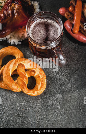 Sélection de cuisine allemande traditionnelle Oktoberfest. La bière, le jarret de porc au four, popcorn, réplique des saucisses, des bretzels. On a black sto Banque D'Images