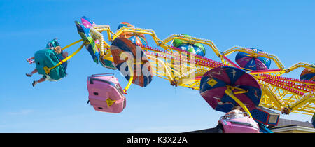 Les gens sur le terrain d'une foire ride sur hasting front de mer, au Royaume-Uni. Banque D'Images