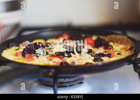 Omelette aux légumes dans une poêle sur la cuisinière. Banque D'Images