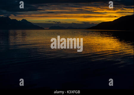 Lever du soleil reflétée dans la mer à Lyngenfjord au nord du cercle arctique, en Norvège au cours de l'été. Banque D'Images