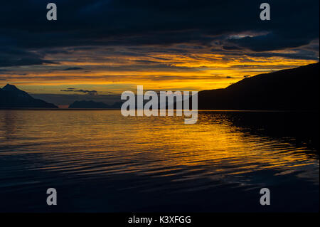 Lever du soleil reflétée dans la mer à Lyngenfjord au nord du cercle arctique, en Norvège au cours de l'été. Banque D'Images