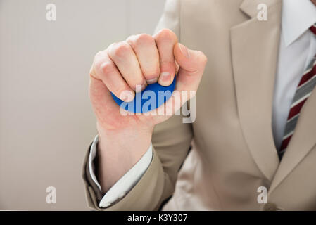 Close-up d'affaires Part Squeezing Stressball dans la main Banque D'Images