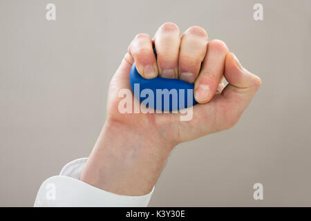 Close-up d'affaires Part Squeezing Stressball dans la main Banque D'Images