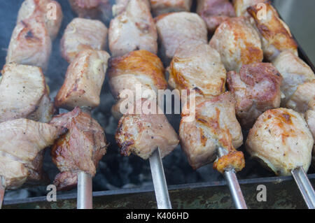 Morceaux de viande de porc juteux de plein air cuit sur les carbones qui couve Banque D'Images