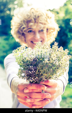 Jeune femme avec un bouquet de fines herbes. Iguzquiza, Navarre, Espagne, Europe. Banque D'Images