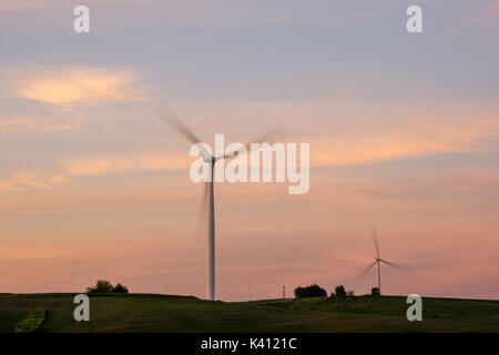 Lever du soleil au centre de l'Iowa, avec une paire d'éoliennes. Banque D'Images