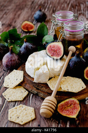 Figues avec du fromage et du miel sur une table en bois, selective focus Banque D'Images