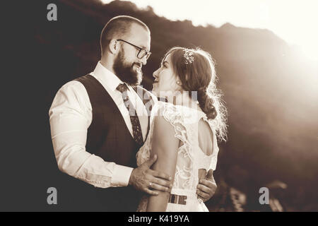 Bride and Groom hugging passionatelly au coucher du soleil, le noir et blanc Banque D'Images