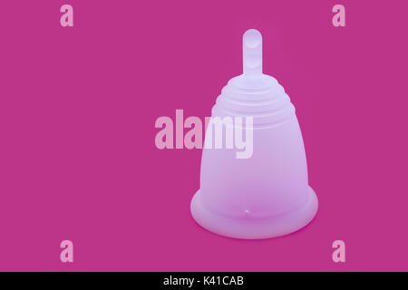 Gros plan d'une coupe menstruelle en silicone avec un fond rose Banque D'Images