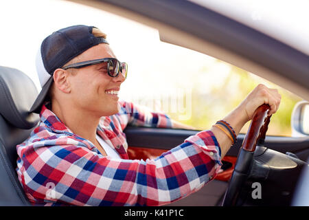 Heureux jeune homme dans des tons driving convertible car Banque D'Images