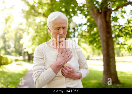 Woman sensation de malaise au parc d'été Banque D'Images