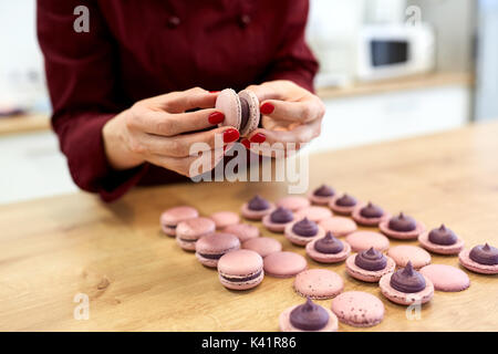 Chef de l'insertion macarons à la crème coquilles Banque D'Images