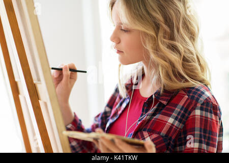 Fille étudiante avec la peinture de chevalet à l'école d'art Banque D'Images