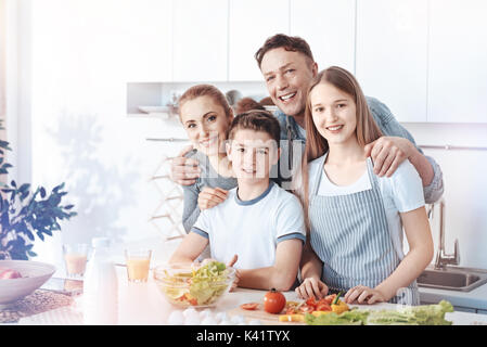 Radiant family posing for camera pendant la cuisson Banque D'Images