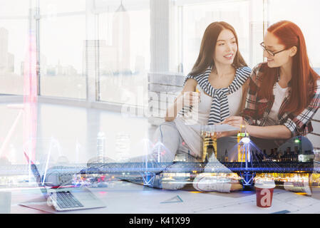 Beaux jeunes travailleurs assis dans leur bureau Banque D'Images