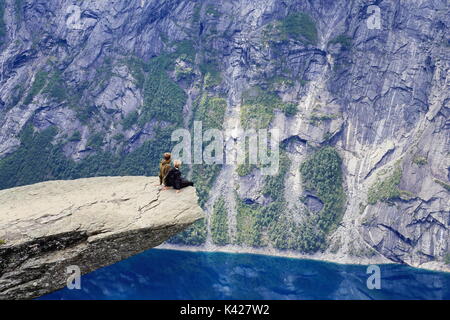 Couple de randonneurs enjoying view de Trolltunga rock formation en Norvège Banque D'Images