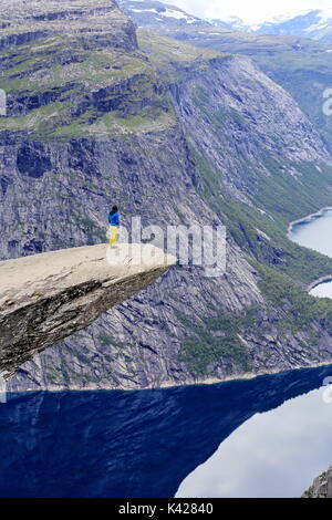 Randonneur enjoying view de trolltunga rock formation en Norvège Banque D'Images