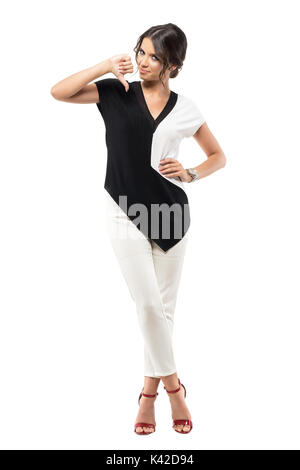 Smiling young business woman showing thumb down part signer looking at camera. La pleine longueur du corps portrait isolé sur fond blanc studio Banque D'Images