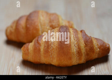 Close up de deux petits croissants sur une planche à découper en bois Banque D'Images