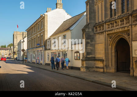 Bury St Edmunds Suffolk, un groupe de touristes d'âge moyen à pied devant l'entrée de cathédrale St Edmundsbury sur Angel Hill dans le centre-ville, au Royaume-Uni. Banque D'Images