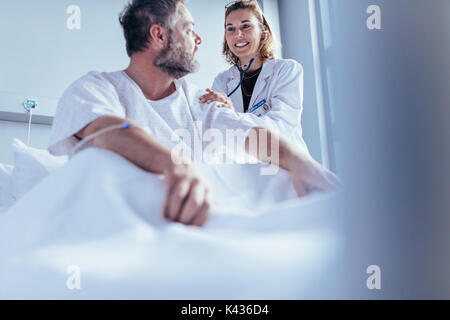 Le médecin de contrôle du patient hospitalisé. Médecin un patient en consolant Ward à l'hôpital. Banque D'Images
