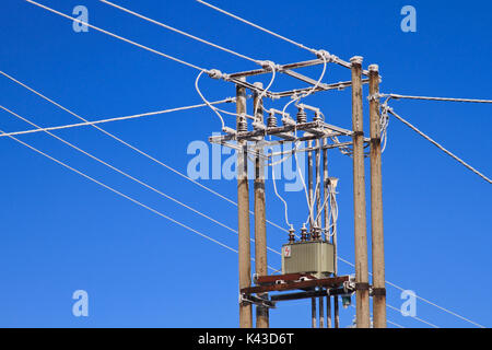 Poteau électrique et câbles couvert de givre sur fond de ciel bleu. Banque D'Images