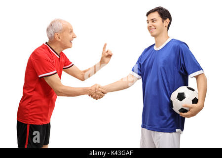 Ancien joueur de foot en serrant la main d'un jeune joueur et lui conseillant isolé sur fond blanc Banque D'Images