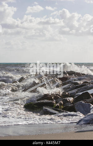 MARINA DI MASSA, ITALIE - 17 août 2015 : Les vagues s'écraser dans les rochers à Marina di Massa, Italie Banque D'Images